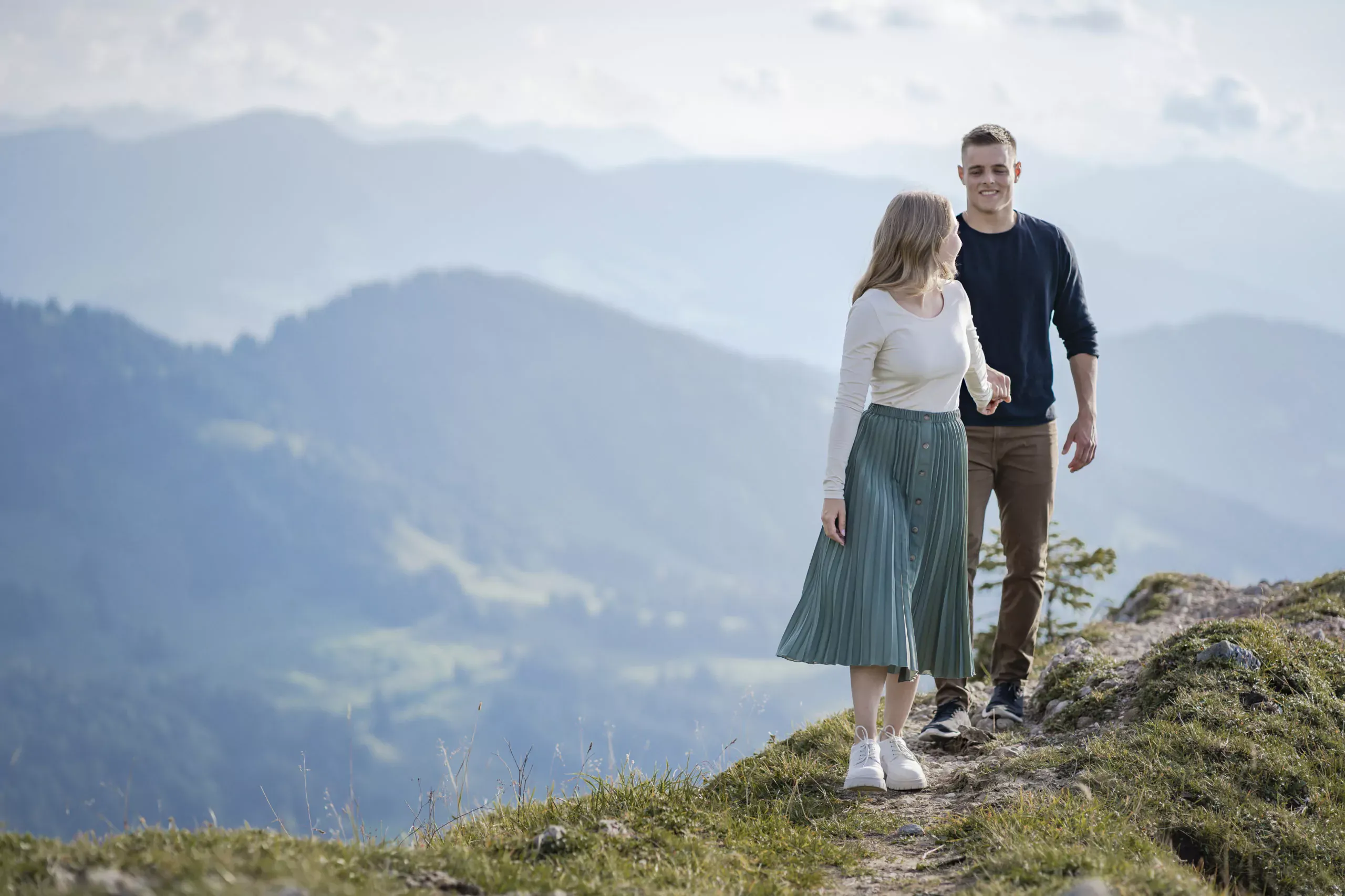 Paar genießt den Sonnenuntergang auf dem Gipfel des Hochgrat mit Bergpanorama